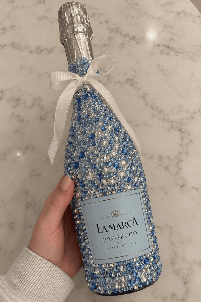 Champagne bottle decorated with colorful rhinestones and gems, a glamorous bedazzled DIY idea for weddings, bachelorette parties, celebrations, or gifts.