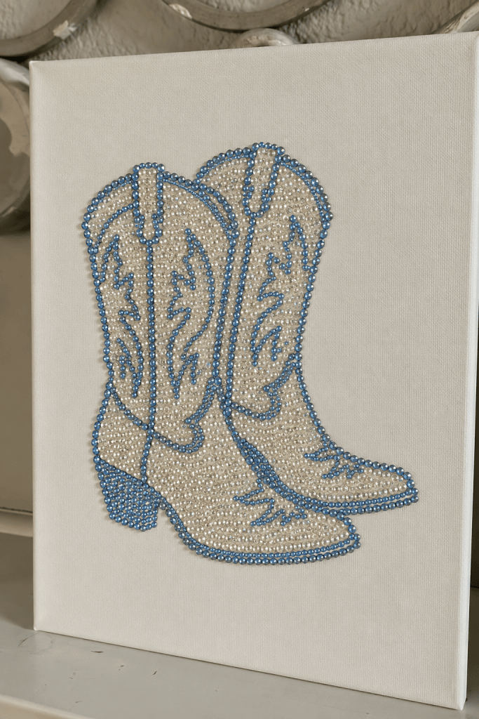 Cowboy boot canvas art decorated with colorful rhinestones and gems, a trendy western bedazzling craft idea for wall decor, girls night, or handmade gifts.